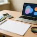 Bureau professionnel avec des documents vierges, un ordinateur affichant une interface abstraite, une calculatrice et des dossiers colorés, illustrant la comparaison de propositions d’agences web pour une PME.