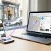 Smartphone, ordinateur portable et carte locale reliés par des lignes lumineuses pour illustrer une stratégie de référencement local coordonnée.